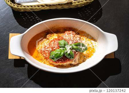 Lasagna portion, oven baked lasagne, pasta layers with cheese, minced meat, tomato in sunny summer day Lasagna portion, oven baked lasagne, pasta layers with cheese, minced meat, tomato in sunny summer day 120137242