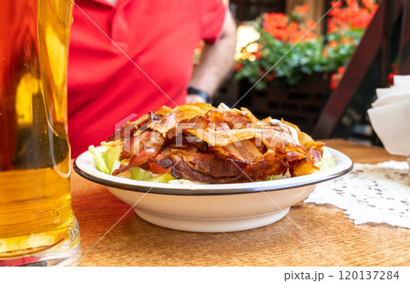 Polish Caesar salad with chicken, bacon and vegetables, high-calorie meat salad with fresh vegetables Polish Caesar salad with chicken, bacon and vegetables, high-calorie meat salad with fresh vegetables 120137284