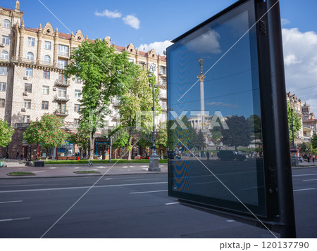 【ウクライナ】首都キーウの道路沿いの看板に反射した独立広場の塔 120137790