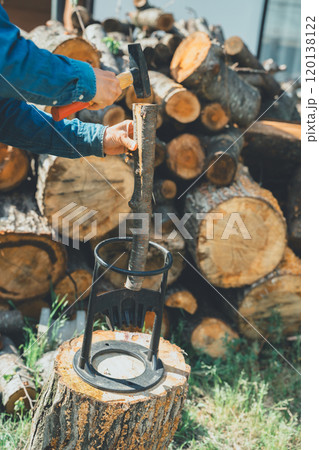薪割り台に薪を置いてハンマーで叩く 120138122