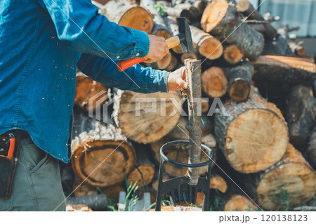 薪割り台に薪を置いてハンマーで叩く 薪割り台に薪を置いてハンマーで叩く 120138123