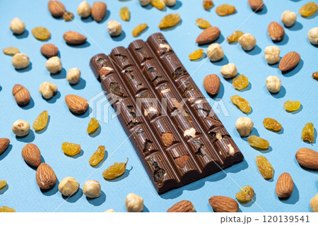 Chocolate bar with nuts and raisins on blue background top view 120139541