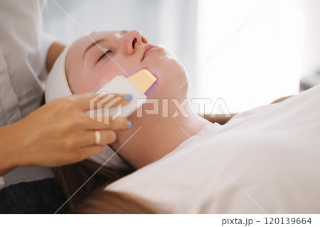 Female at cosmetic beauty spa clinic has facial hardware cosmetology. Woman making beauty procedures Female at cosmetic beauty spa clinic has facial hardware cosmetology. Woman making beauty procedures 120139664