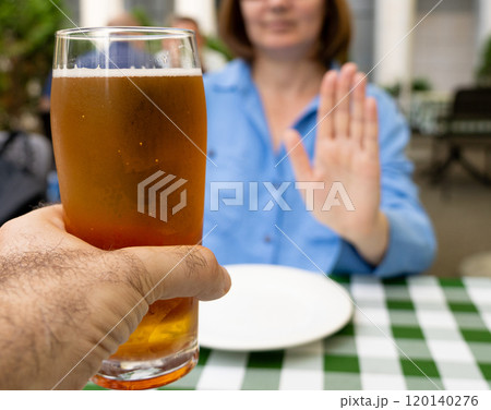 Reject a glass of beer, woman refusing alcohol, stop drinking, sobriety concept, saying no to beer glass 120140276