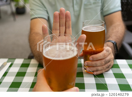 Reject a glass of beer, man refusing alcohol, stop drinking, sobriety concept, saying no to beer glass Reject a glass of beer, man refusing alcohol, stop drinking, sobriety concept, saying no to beer glass 120140279