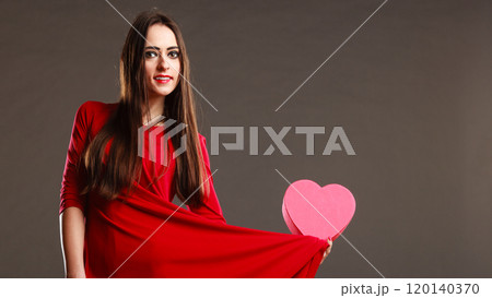 Woman red dress holds heart shaped box 120140370