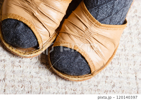 Woman feet with socks in slippers at home Woman feet with socks in slippers at home 120140397