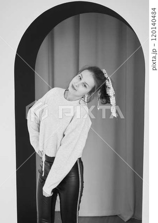 black and white portrait of a teenage girl in front of an arch 120140484