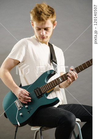 Young man playing electric guitar Young man playing electric guitar 120140507