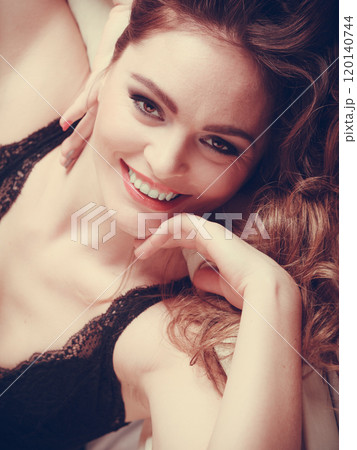 Portrait of happy young woman in lingerie in bed. 120140744