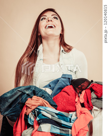 Smiling girl hold pile of clothes. 120140815