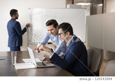 Two diverse business coworker men watching Internet project presentation 120141004