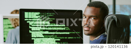 Young African American male cybersecurity specialist sitting at workplace taking off his eyeglasses and looking at camera, website header Young African American male cybersecurity specialist sitting at workplace taking off his eyeglasses and looking at camera, website header 120141136