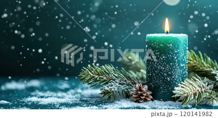 Green candle surrounded by snowy pine branches 120141982