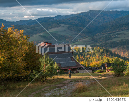A hiker approaching mountain lodge 120143678