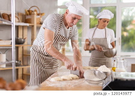 Elderly man and woman whipping and braiding dough Elderly man and woman whipping and braiding dough 120143977