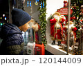 Child looking at festive toy display in Christmas shop window for holiday magic Happy New Year.  120144009