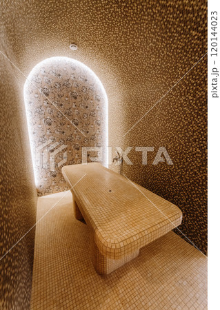 Luxurious spa steam room with tiled massage table and ambient lighting for ultimate relaxation 120144023