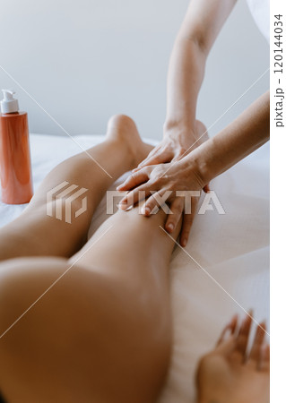 Professional leg massage therapy for relaxation, rejuvenation, and wellness at a luxury spa 120144034