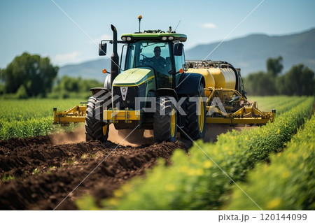 A farmer fertilizes plants with the help of a tractor and a sprayer. 120144099