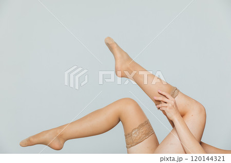 Beautiful women's legs in tights, stockings on a white background 120144321