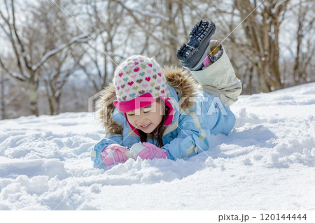 公園の雪で遊ぶ女の子 120144444