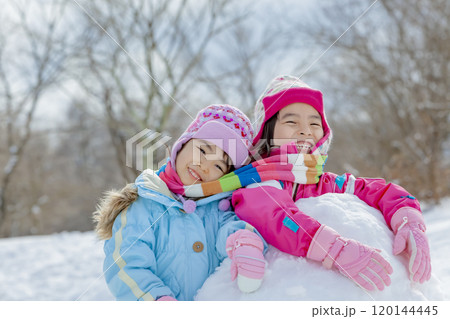 雪の公園でマフラーを巻いて遊ぶ姉妹 雪の公園でマフラーを巻いて遊ぶ姉妹 120144445
