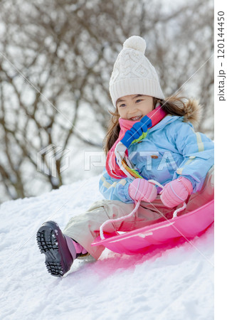 雪の公園でソリ遊びをする女の子 雪の公園でソリ遊びをする女の子 120144450