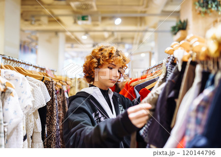 portrait of red-haired attractive young woman trying on clothes in store portrait of red-haired attractive young woman trying on clothes in store 120144796