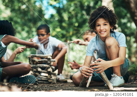 Learning how to build our own barbecue. Shot of a group of teenagers building a pile of wood at summer camp. 120145101