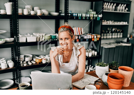 I am always working to improve my business. Cropped portrait of an attractive mature woman sitting alone and using her laptop in her pottery workshop. 120145140