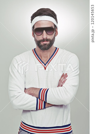 Retro confidence. Portrait of a young man standing with his arms folded in the studio. 120145653