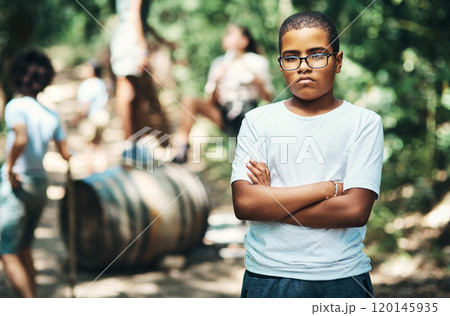 Im the boss on this side of the bush. Shot of a teenage boy looking unhappy at summer camp. 120145935