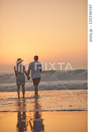 Lets get wet and wild. Rearview shot of a mature couple spending quality time on the beach. 120146597