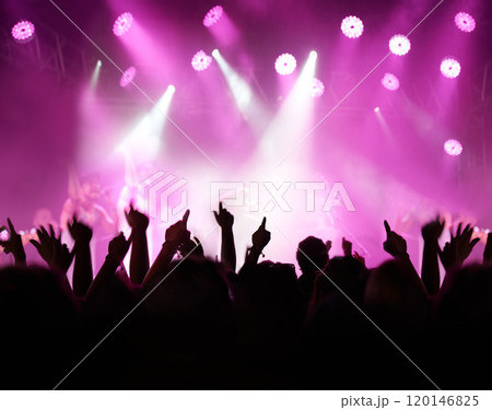 Throw your hands up. Rearview of an audience with hands raised at a music festival and lights streaming down from above the stage. Throw your hands up. Rearview of an audience with hands raised at a music festival and lights streaming down from above the stage. 120146825