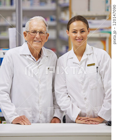 Offering their clients a world of medicinal knowledge. Shot of an elderly pharmacist and a young pharmacist standing at counter. 120147090
