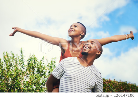 She deserves to feel on top of the world. Cropped shot of a young man giving his girlfriend a piggyback ride. 120147100
