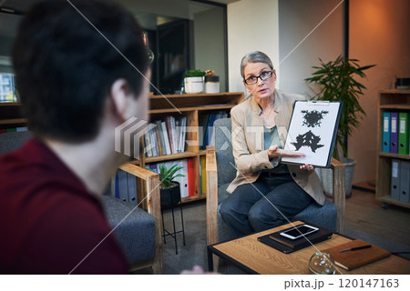So much more than just an ink splatter. Shot of a mature psychologist conducting an inkblot test with her patient during a therapeutic session. 120147163