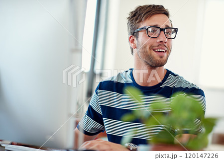 Its always a good day in this office. Shot of a casually-dressed young man at work on a computer. Its always a good day in this office. Shot of a casually-dressed young man at work on a computer. 120147226
