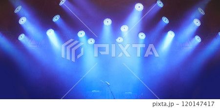 An empty stage - evoking anticipation. A stage at a music festival with lights streaming down from above. An empty stage - evoking anticipation. A stage at a music festival with lights streaming down from above. 120147417