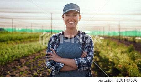 Life on the farm is awesome. Cropped portrait of an attractive young female farmer standing with her arms crossed while working on the farm. 120147630