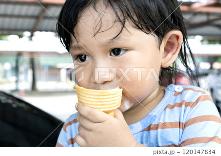 Little boy eating ice cream in the summer. 120147834