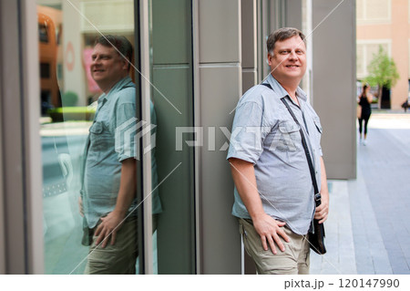 Adult blond man in short sleeve shirt on the street of a big city 120147990