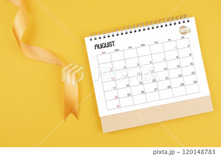 August 2025 desk calendar with yellow ribbon on yellow background. August 2025 desk calendar with yellow ribbon on yellow background. 120148783