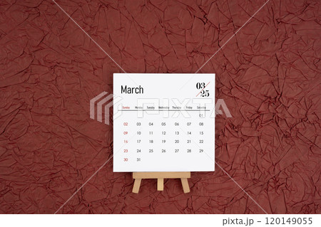 March 2025 calendar on red crumpled paper background. Directly above. March 2025 calendar on red crumpled paper background. Directly above. 120149055