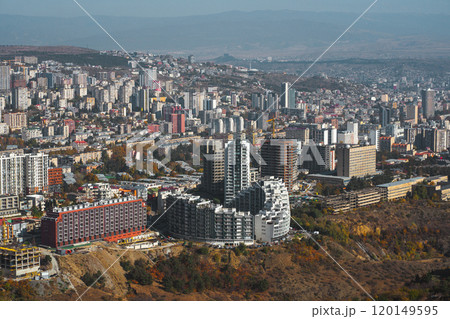 A vibrant cityscape showcasing modern architecture and natural beauty along the hillside during autumn 120149595