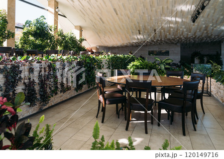 Cozy dining area surrounded by lush plants in a modern interior space showcasing natural elegance 120149716