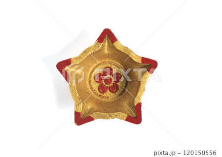 Top view of a star shaped decorative diwali oil lamp (diya) on white background Top view of a star shaped decorative diwali oil lamp (diya) on white background 120150556