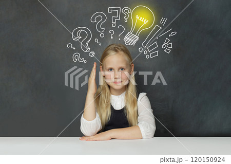 Happy child girl student with yellow light bulb and question marks on school blackboard background Happy child girl student with yellow light bulb and question marks on school blackboard background 120150924