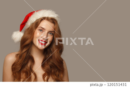 Joyful Christmas woman in Santa hat with make-up and cute positive smile Joyful Christmas woman in Santa hat with make-up and cute positive smile 120151431